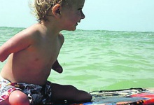 Дитина-інвалід катається на серфі