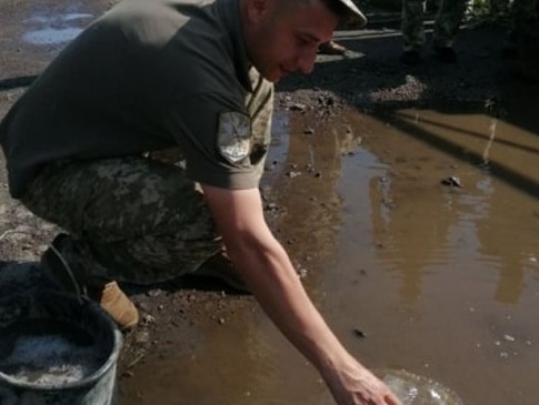 У Луцьку військові до приїзду Зеленського пластиковими пляшками вичерпували воду з ям на дорозі